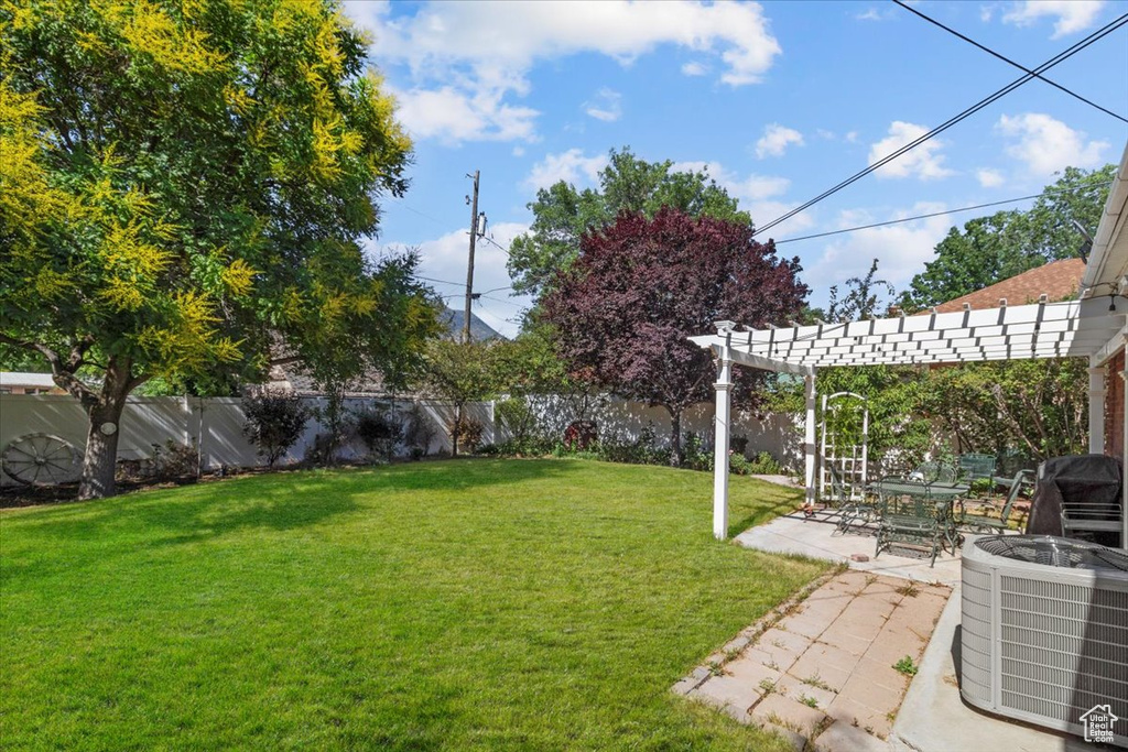 View of yard with a pergola, a patio, and central AC unit