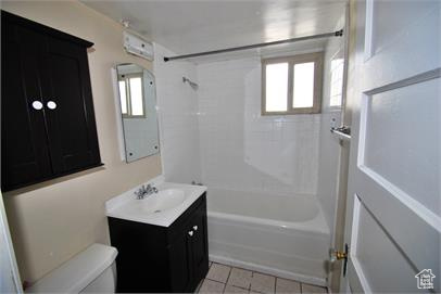 Full bathroom featuring tile floors, shower / washtub combination, oversized vanity, and toilet