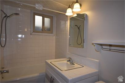 Full bathroom with toilet, vanity, and tiled shower / bath