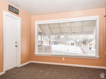 Empty room featuring dark colored carpet