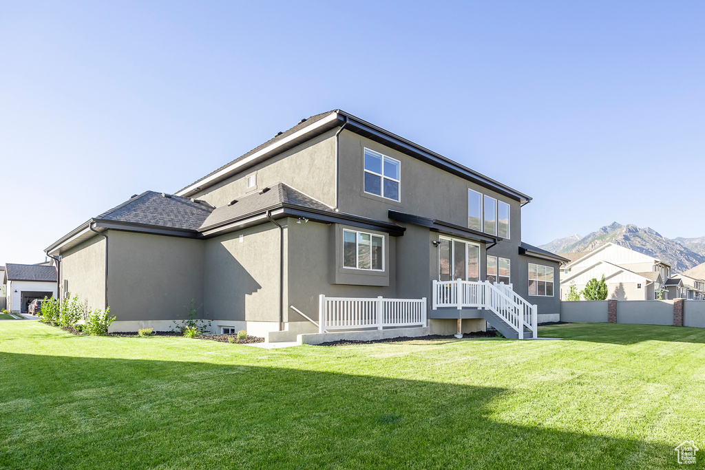 Back of property featuring a lawn and a mountain view