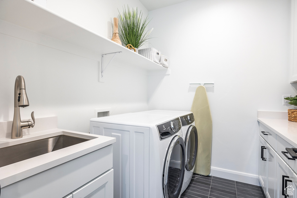 Laundry room featuring independent washer and dryer, cabinets, dark tile flooring, washer hookup, and sink