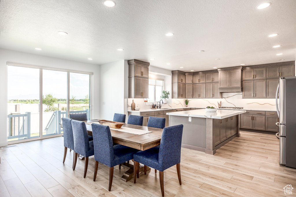 Dining space featuring light hardwood / wood-style floors, sink, and a textured ceiling