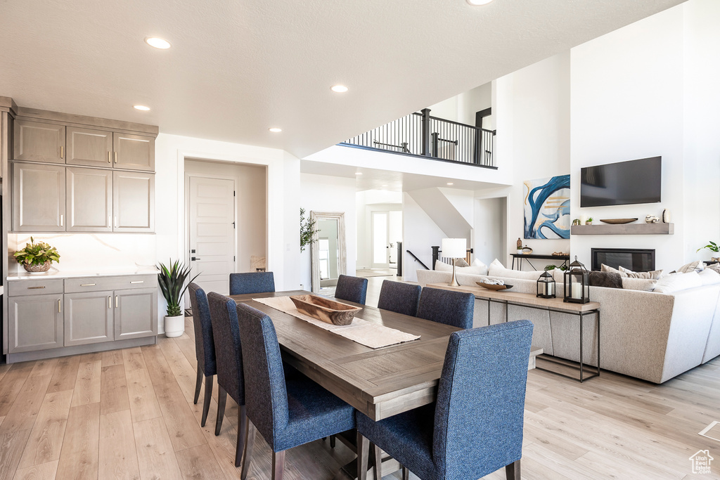 Dining area featuring a towering ceiling and light hardwood / wood-style flooring