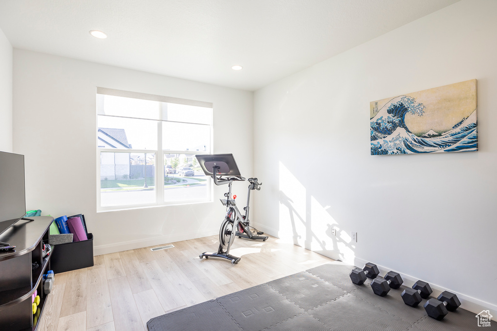 Workout area featuring light wood-type flooring