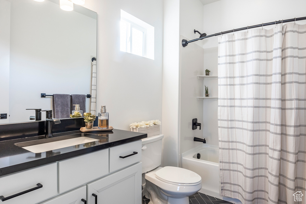 Full bathroom with tile flooring, shower / bath combo, vanity, and toilet