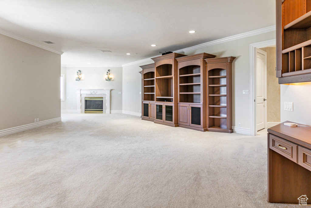 Unfurnished living room featuring crown molding, carpet flooring, and a high end fireplace