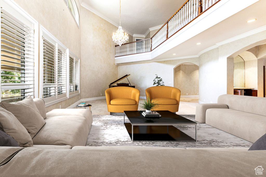 Carpeted living room featuring a high ceiling, ornamental molding, and a chandelier