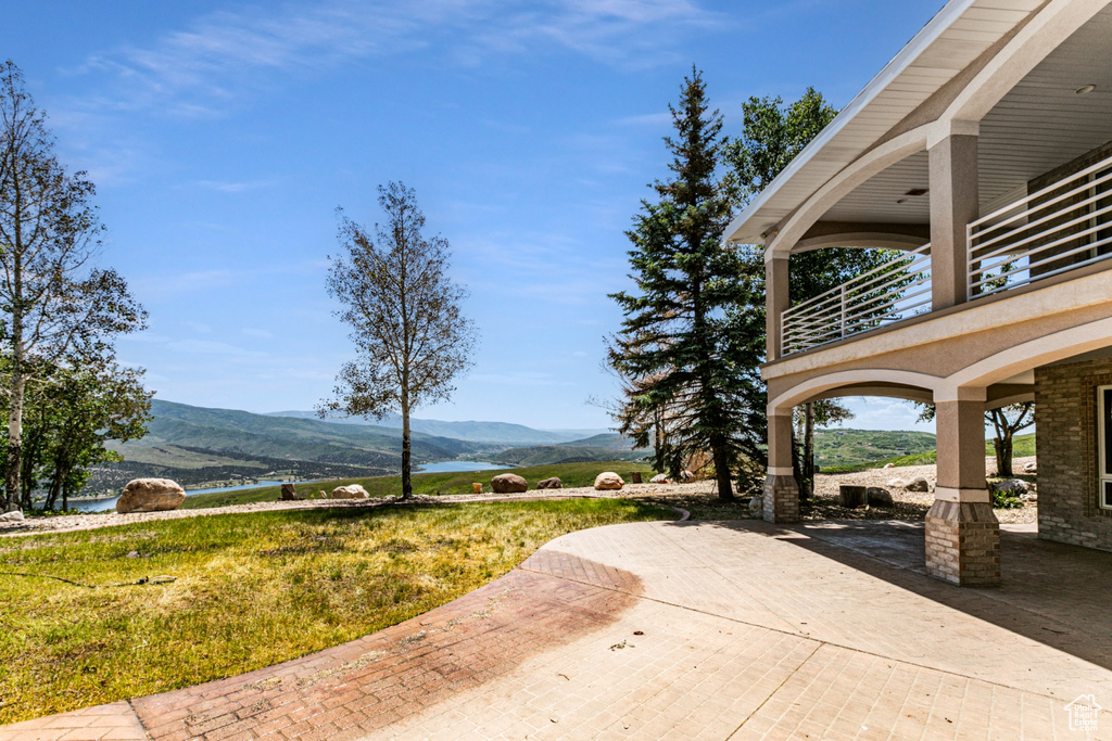 Exterior space featuring a yard, a mountain view, and a patio area