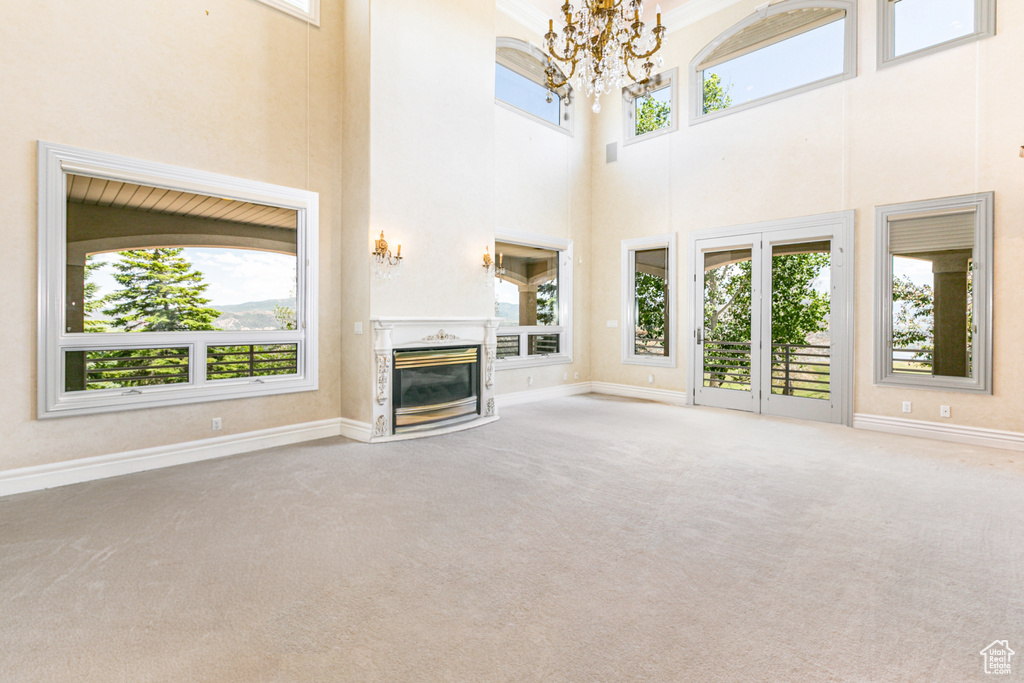 Unfurnished living room featuring a high end fireplace, a wealth of natural light, and carpet flooring