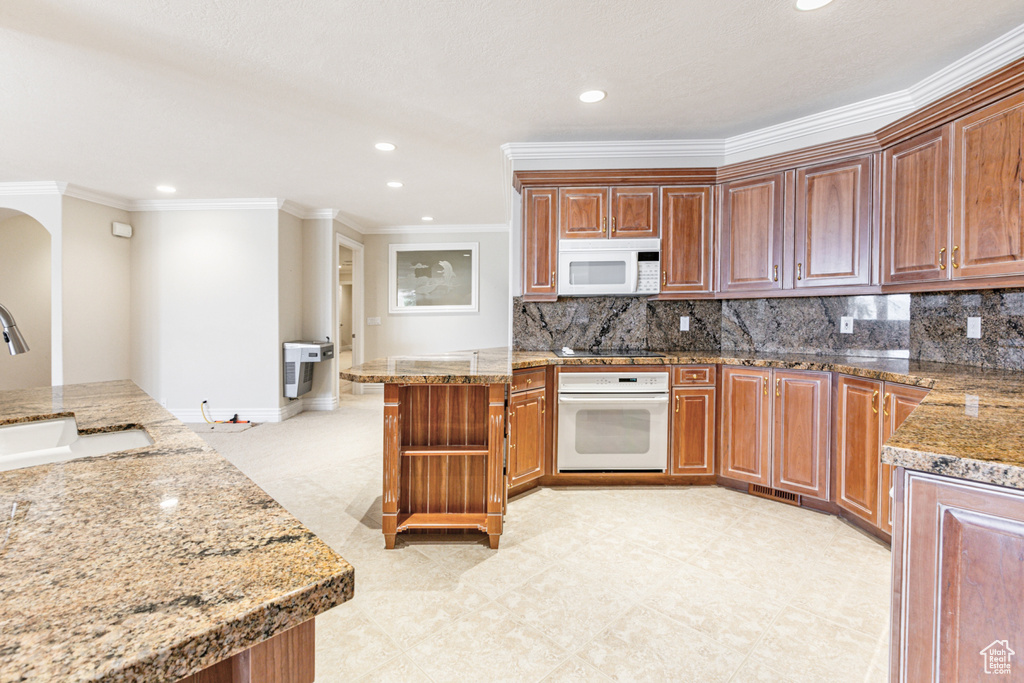 Kitchen with white appliances, sink, tasteful backsplash, and light tile flooring