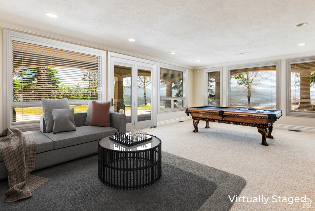 Game room featuring pool table, a textured ceiling, french doors, and ornamental molding