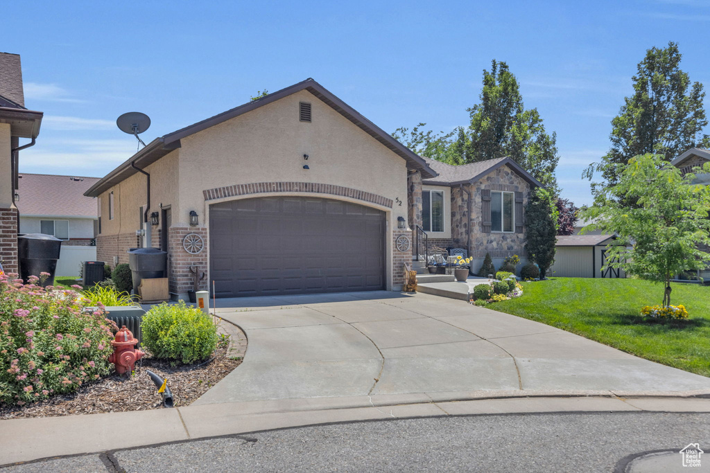 View of front of property featuring a garage and a front yard