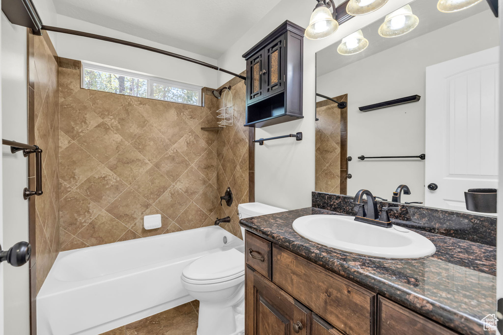 Full bathroom with tile patterned flooring, tiled shower / bath, toilet, and vanity