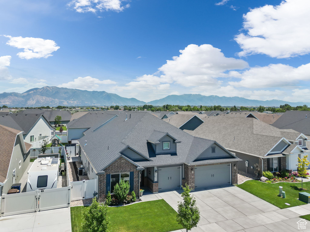 Exterior space with a garage, a front yard, and a mountain view