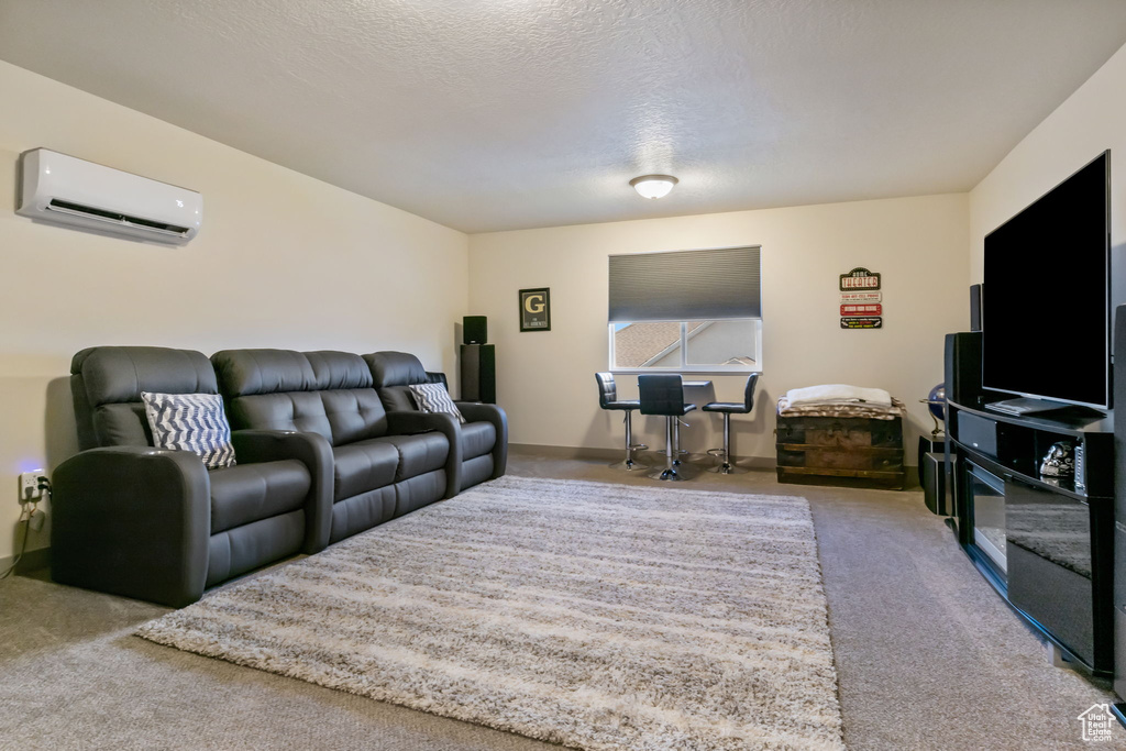 Living room with a wall mounted AC, a textured ceiling, and carpet flooring