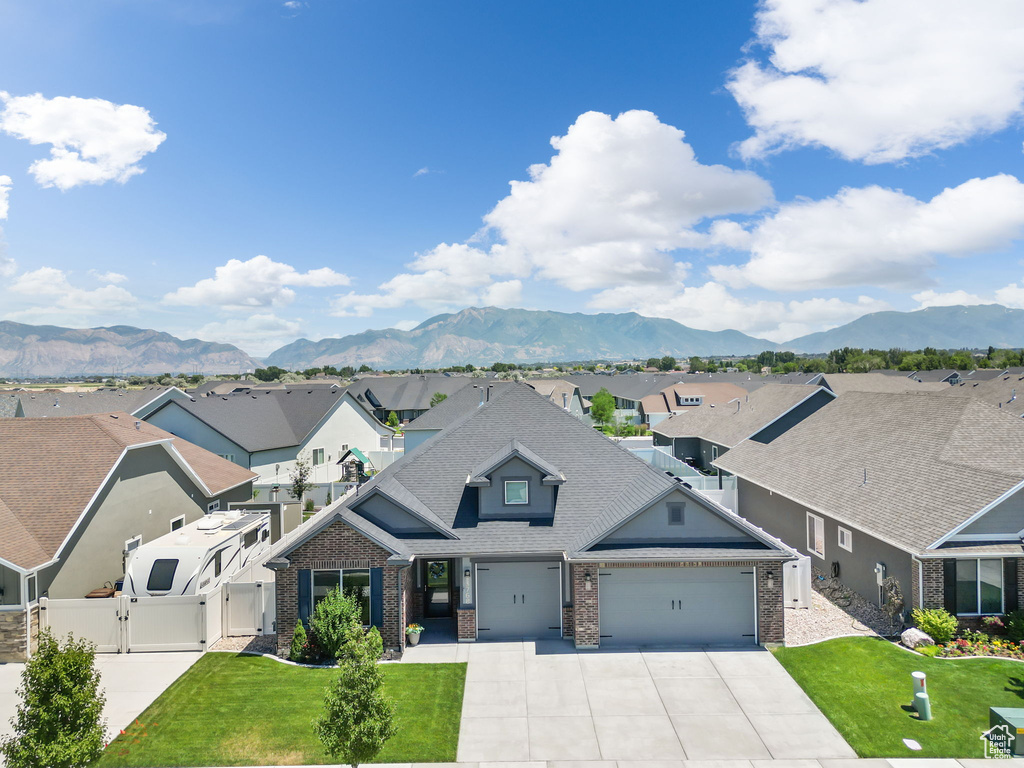 Craftsman inspired home featuring a front lawn, a garage, and a mountain view