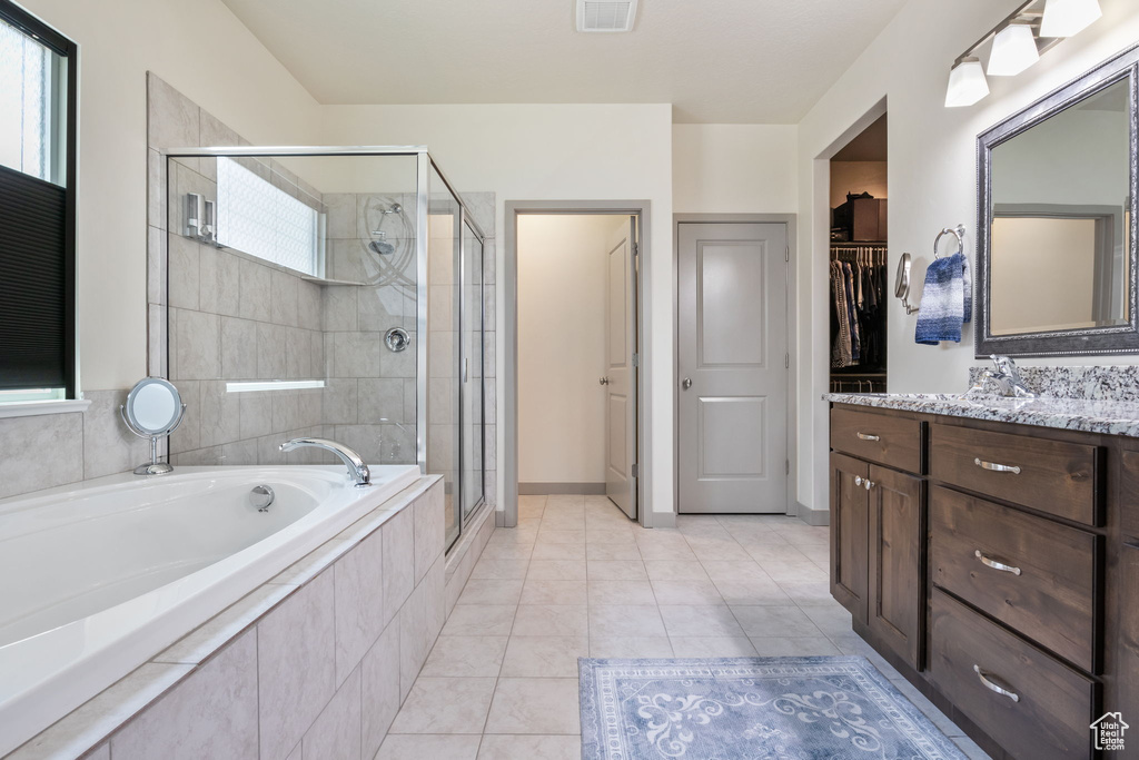 Bathroom with vanity, tile floors, and plus walk in shower