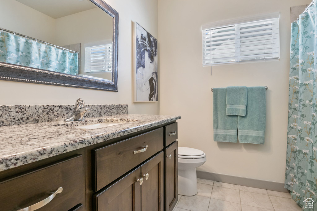 Bathroom with tile floors, vanity, and toilet