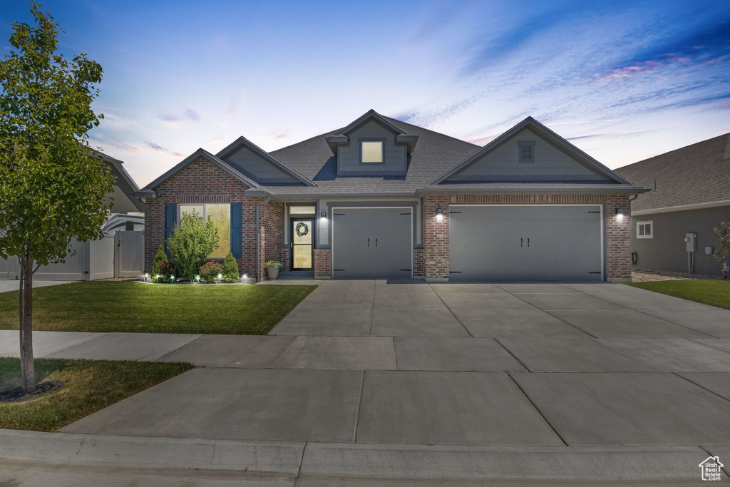 View of front of house featuring a garage and a lawn