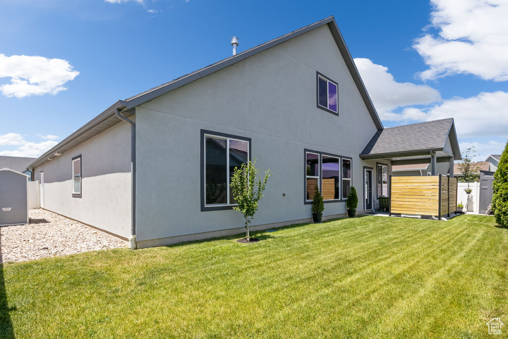 Rear view of house featuring a yard