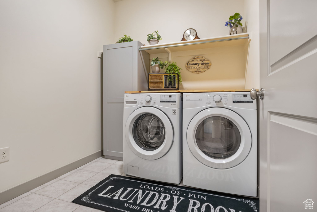 Laundry area featuring washing machine and dryer and light tile floors