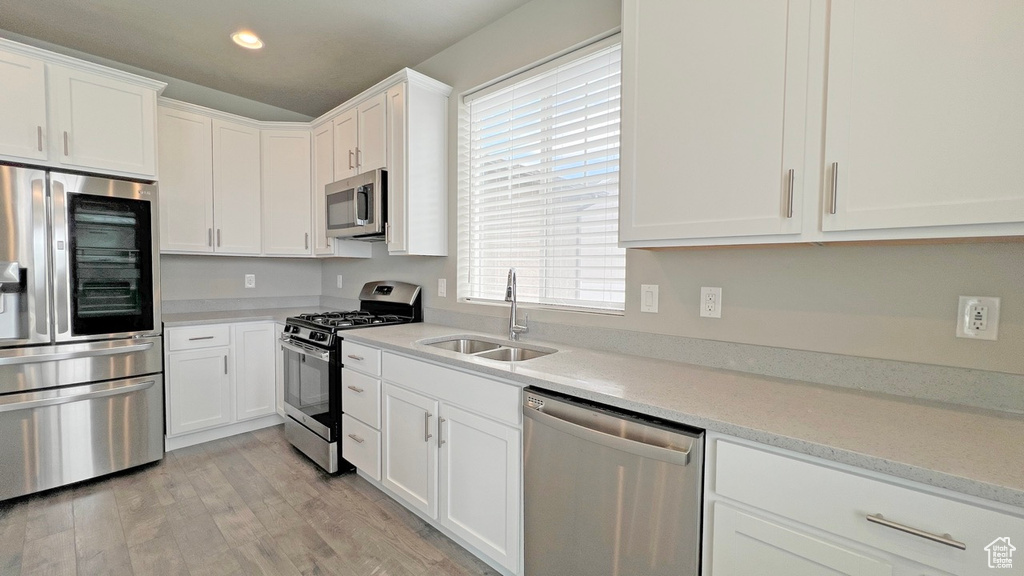 Kitchen featuring sink, light hardwood / wood-style floors, a wealth of natural light, and appliances with stainless steel finishes