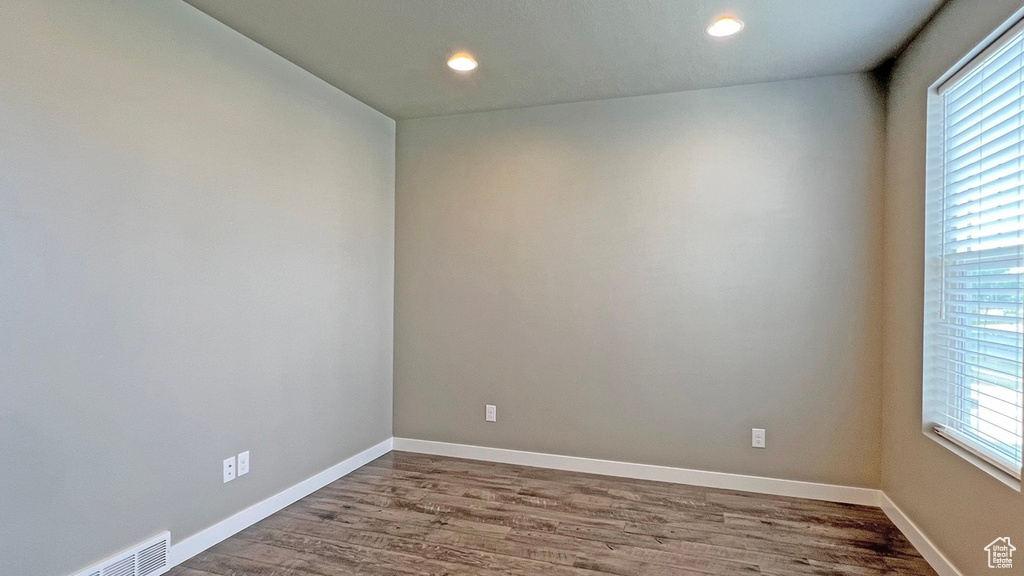 Unfurnished room with a healthy amount of sunlight and hardwood / wood-style flooring