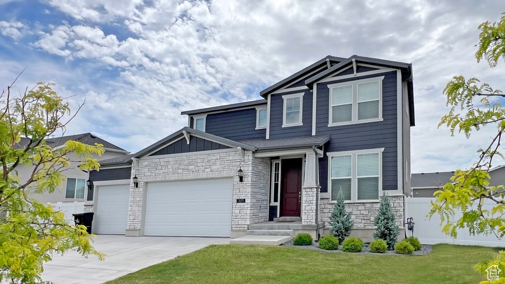 Craftsman-style home featuring a front lawn and a garage