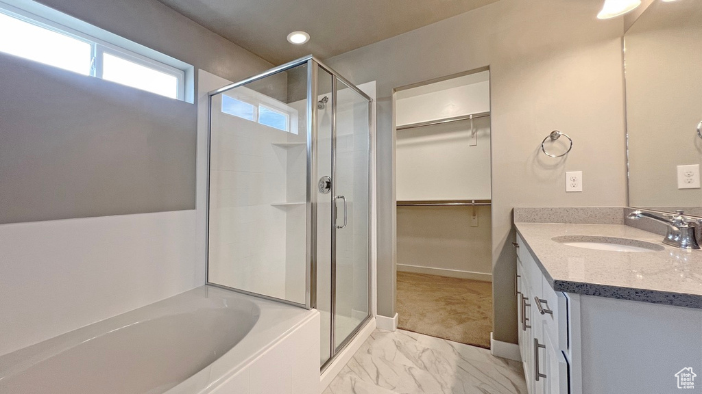 Bathroom with tile flooring, oversized vanity, and plus walk in shower