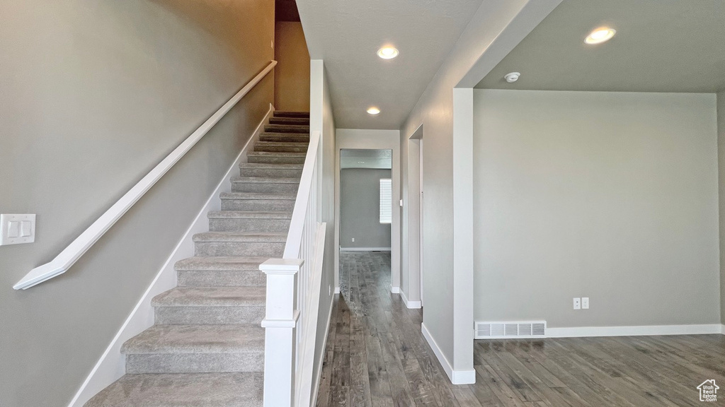 Stairway featuring dark hardwood / wood-style floors