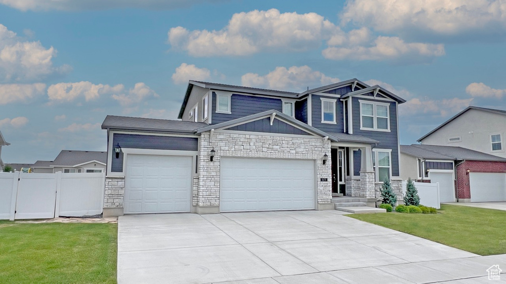 View of front of property featuring a garage and a front yard