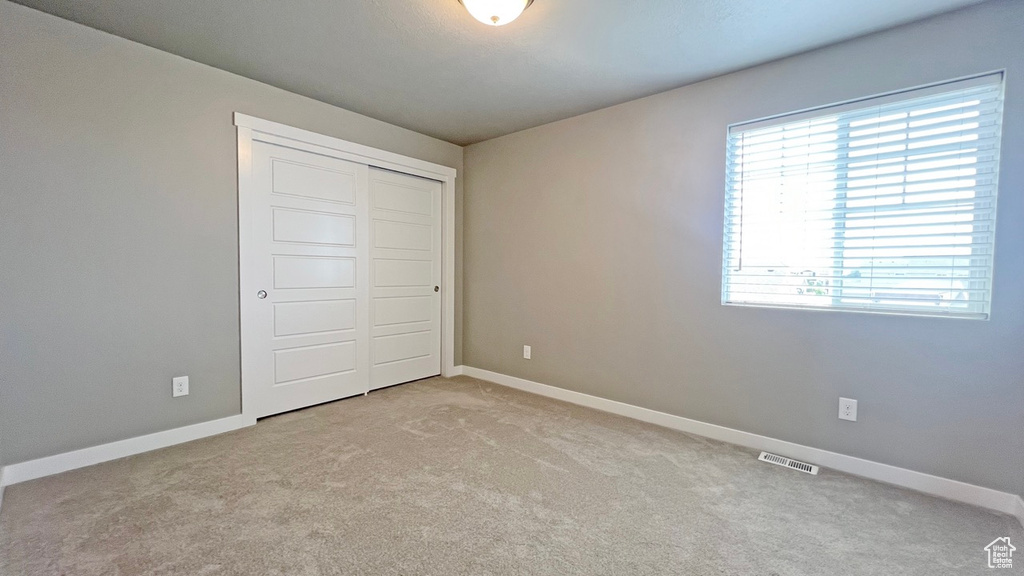 Unfurnished bedroom with a closet and carpet floors