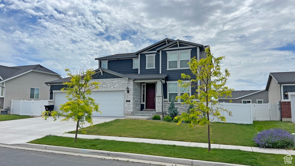 Craftsman inspired home with a garage and a front yard