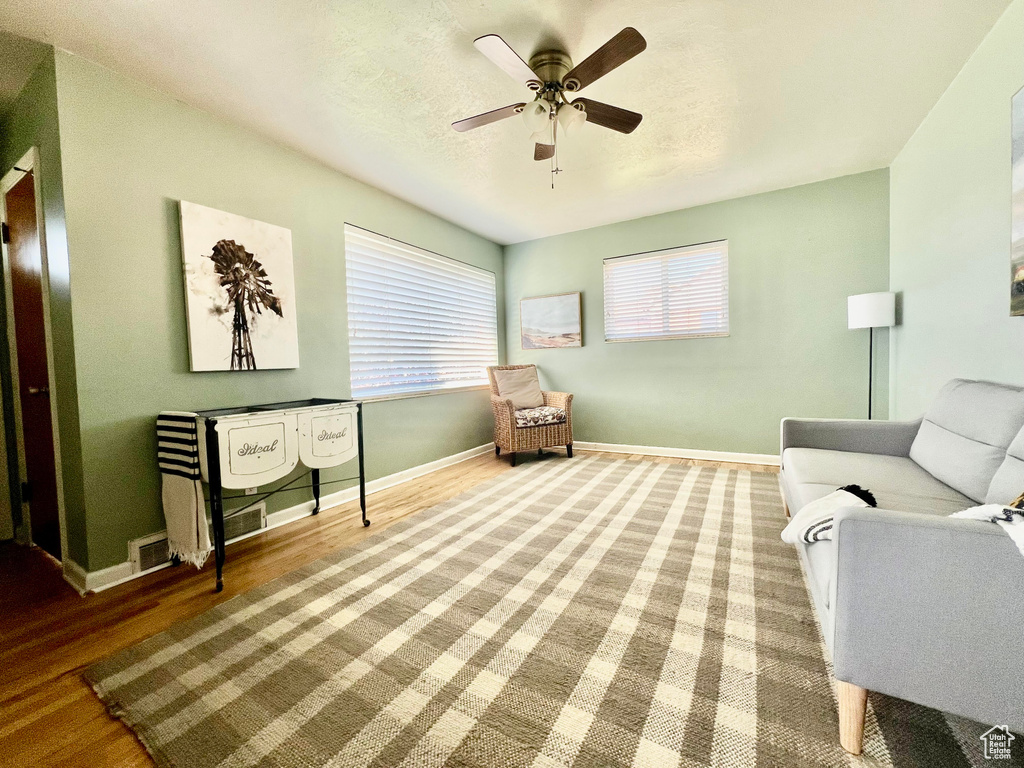 Living area featuring wood-type flooring and ceiling fan