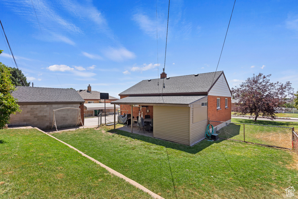 Rear view of property featuring a patio area and a lawn