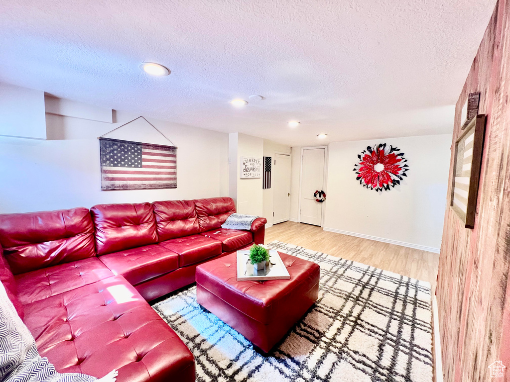 Living room with a textured ceiling and hardwood / wood-style floors