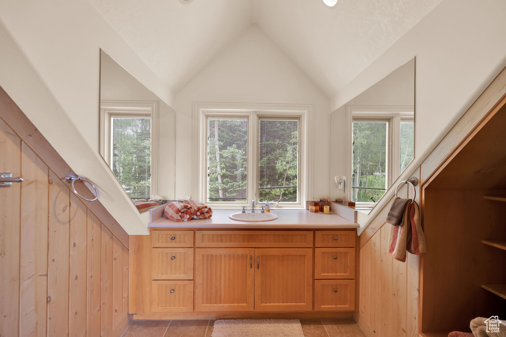 Bathroom featuring tile flooring, lofted ceiling, and vanity