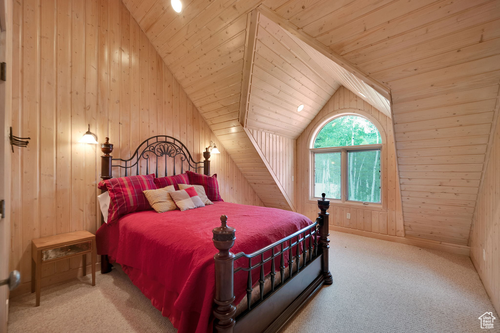 Bedroom featuring carpet, wood walls, and vaulted ceiling