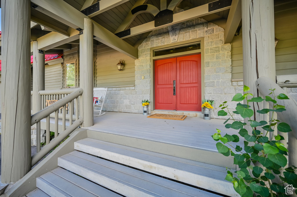 Doorway to property featuring ceiling fan and a porch