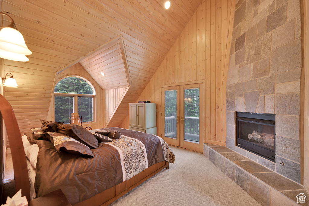 Bedroom featuring a fireplace, access to outside, wooden walls, lofted ceiling, and wooden ceiling