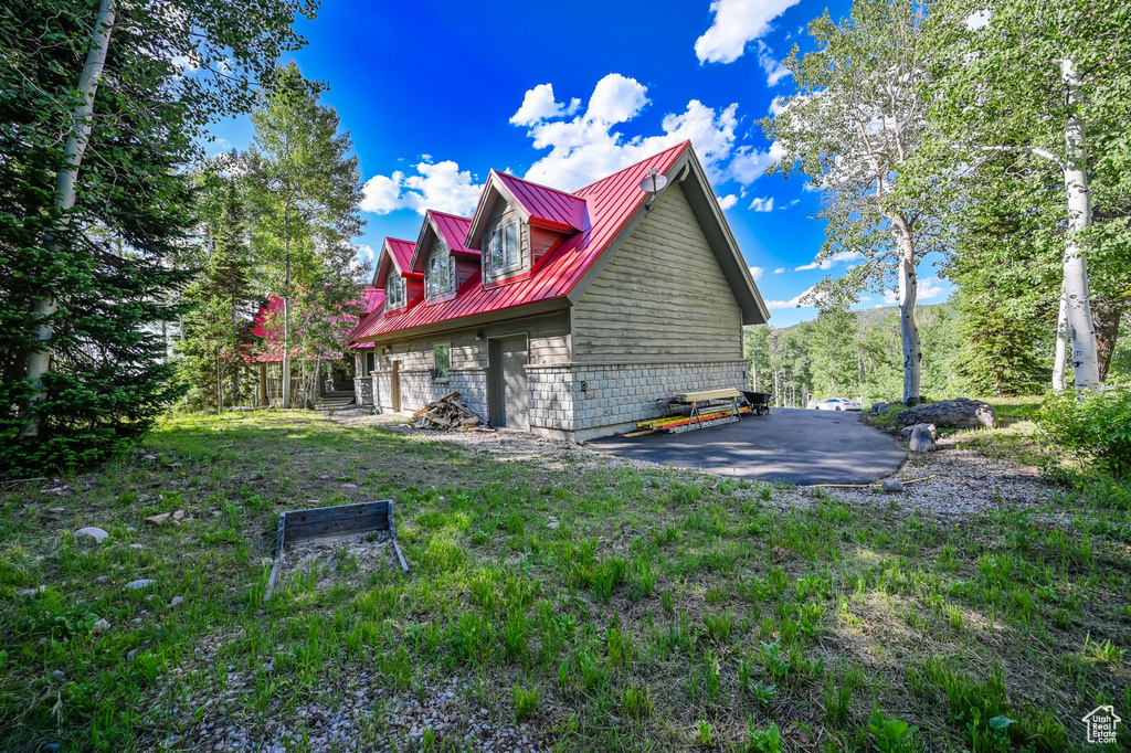 View of property exterior featuring a yard and a patio