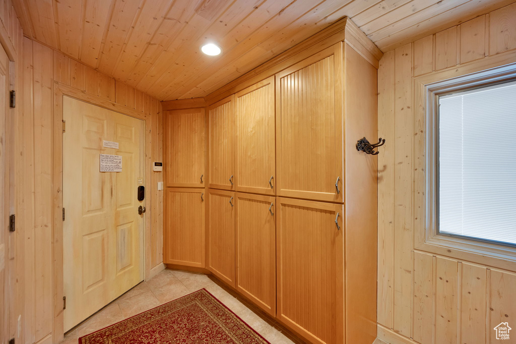 Interior space featuring wood walls, wood ceiling, and light tile floors