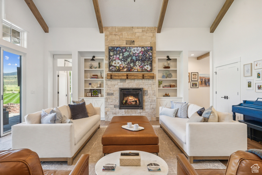 Living room with beam ceiling, high vaulted ceiling, a fireplace, and built in features