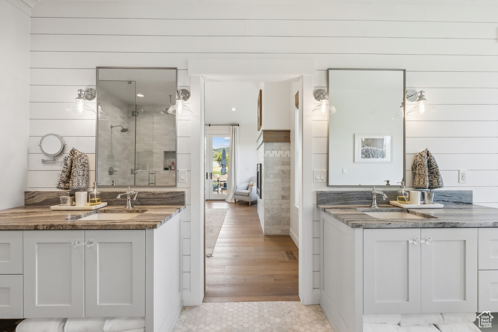 Bathroom with tile floors, dual bowl vanity, and a tile shower