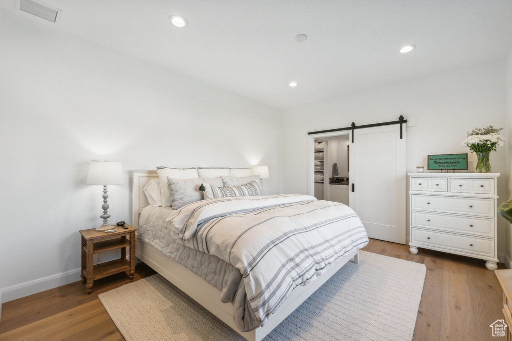 Bedroom featuring hardwood / wood-style floors and a barn door