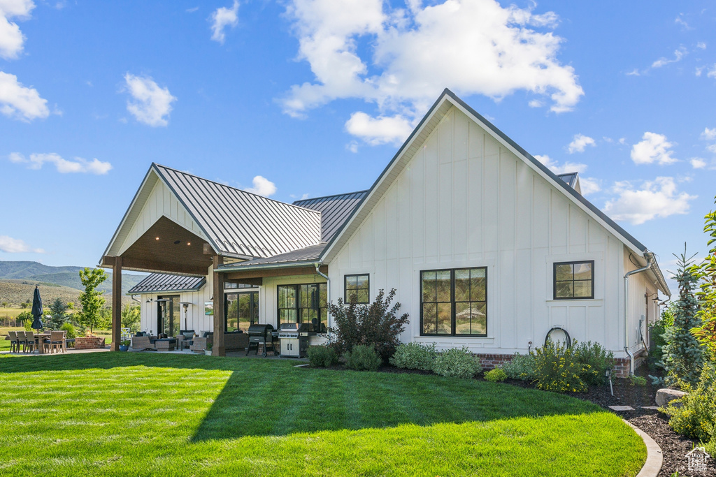 Rear view of property featuring a yard and a patio