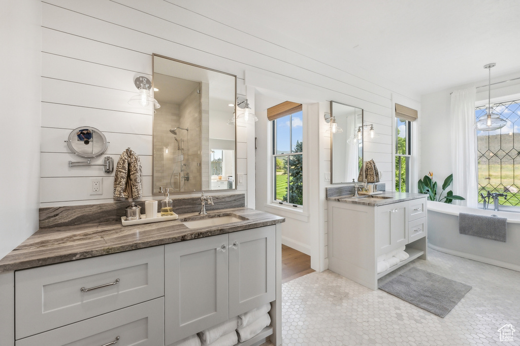 Bathroom with double vanity, wooden walls, and hardwood / wood-style floors