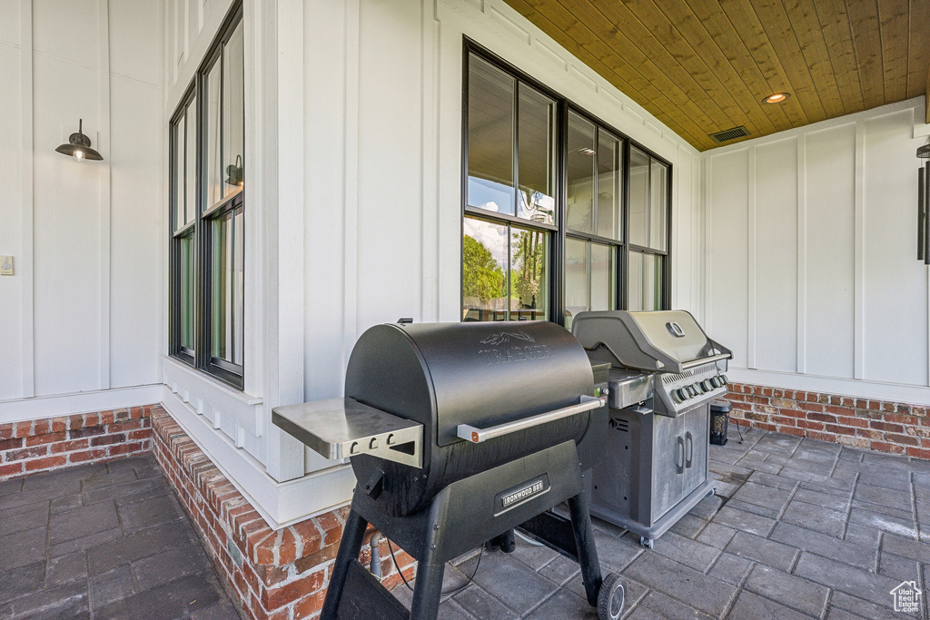 View of patio with a grill and a porch