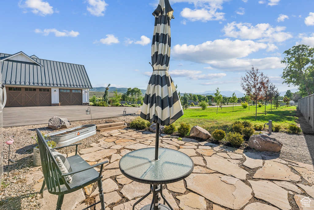 View of patio with an outdoor structure and a garage